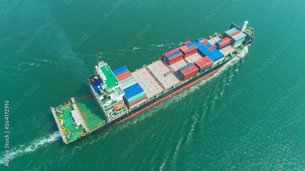 Aerial  container ship on the green sea going to seaport for load container at crane bridge. Logistics, import export, shipping or transportation.
