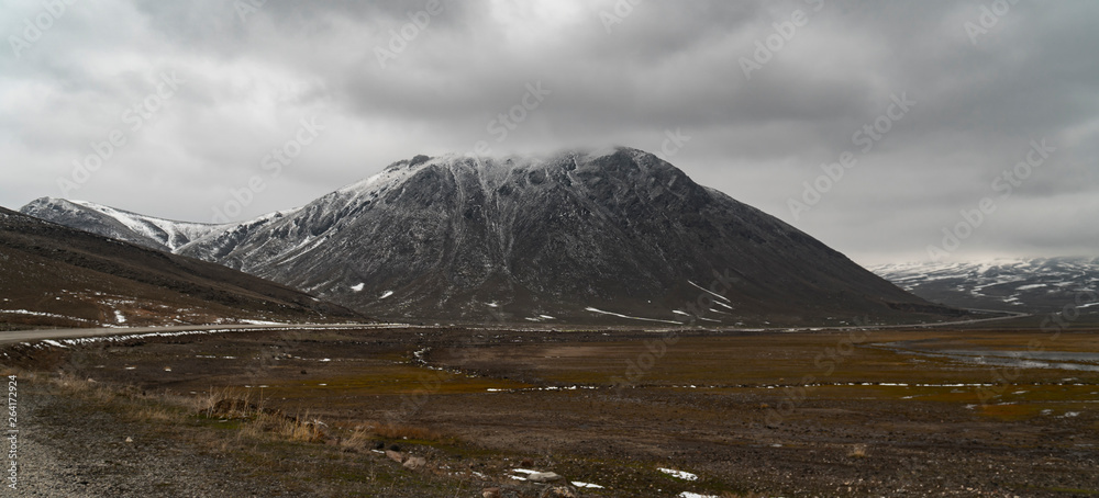 Scenery of high snowy mountain with valley and clouds.