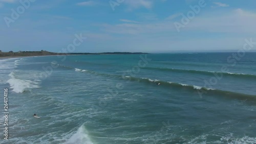 Cinematic drone / aerial footage moving forwards showing a surfer in the water in Kingsburg, Nova Scotia, Canada during summer season. photo