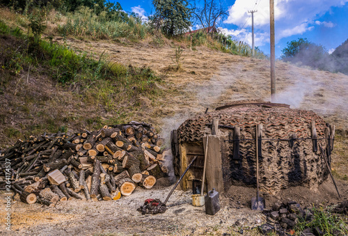 Traditional charcoal pile covered with clay, used for production of charcoal in Serbia photo