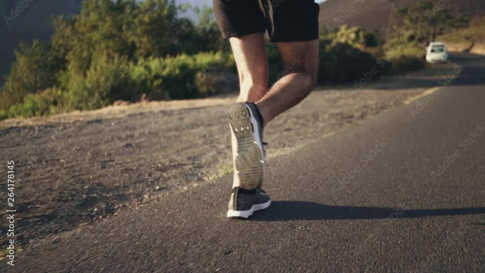 Fit male jogger running on road