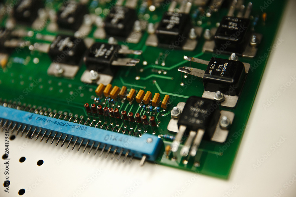 Close up of microelectronics engineering, electronic board circuit through a magnifying glass Close up of microelectronics engineering, electronic board circuit through a magnifying glass