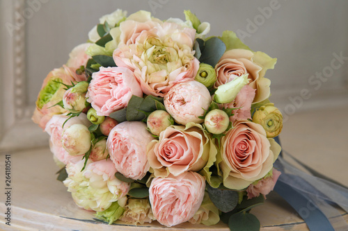 Delicate wedding bouquet of roses, peonies, ranunculus in the interior.