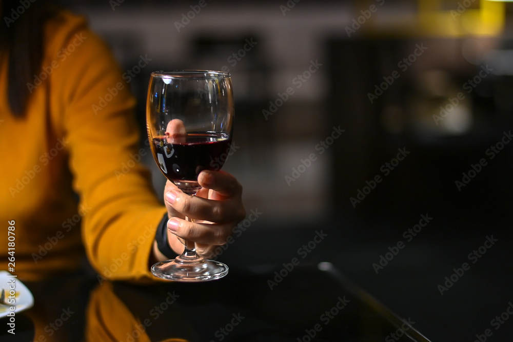 Woman holding a glass of red wine with vintage tone.
