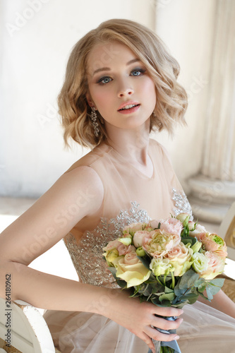 Portrait of a gentle happy elegant bride with a bouquet in her hands.