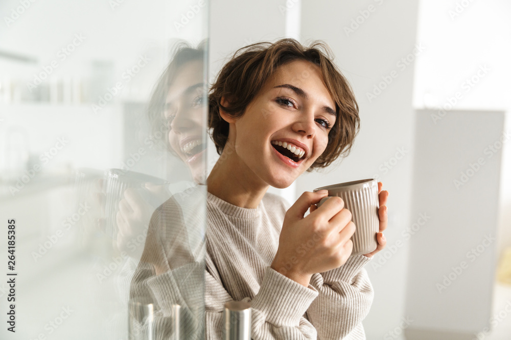 Side view of Happy brunette woman drinking coffee Side view of Happy brunette woman drinking coffee