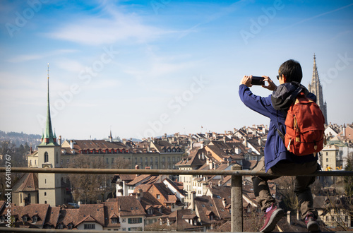 Back view of tourist young man selfie and he's a take a picture by smartphone at old town in Bern city ,Switzerland