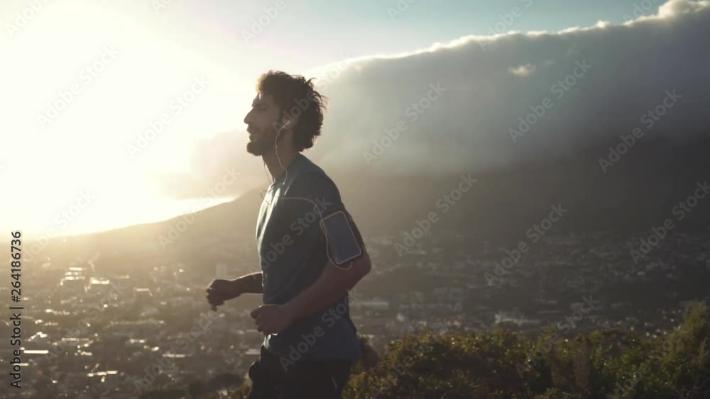 Morning jogger moves hands running up valley hill
