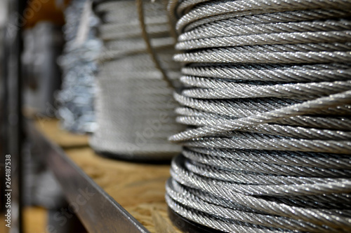 Clean new steel cable, steel wire or steel rope wound on a bobbins standing on a shelf