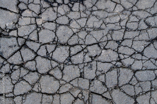 Old worn and cracked asphalt with cracks. Cracked asphalt background