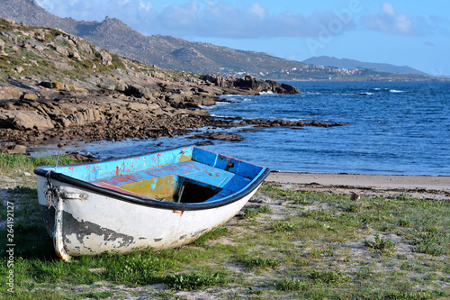 Abandoned traditional fishing rowboat in the Galician coast, Northern Spain photo