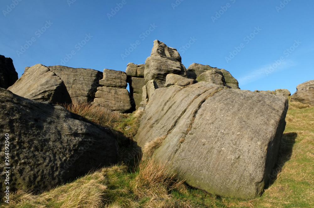 large rugged gritstone outcrop at the bridestones a large rock formation in west yorkshire near todmordenwith blue sky and surrounding countryside