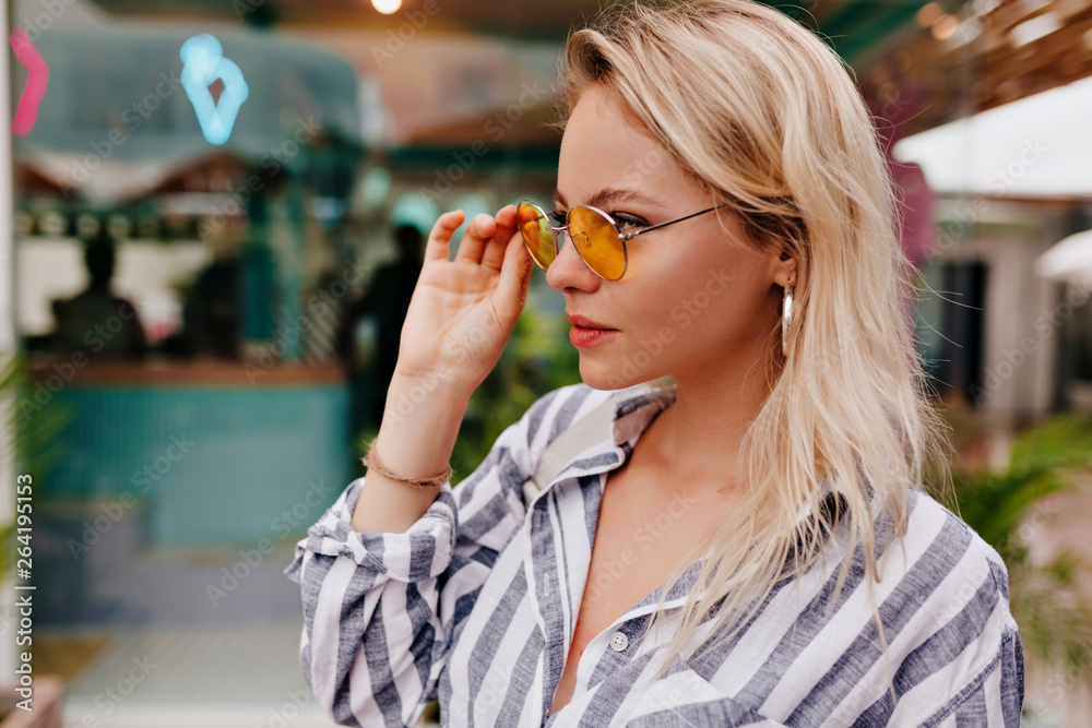 Stylish happy young woman wearing round glasses and stripped shirtt. portrait of smiling girl in sunglasses and bag Stylish happy young woman wearing round glasses and stripped shirtt. portrait of smiling girl in sunglasses and bag