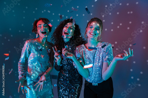 Happy Three beauty women wearing in shiny clothes