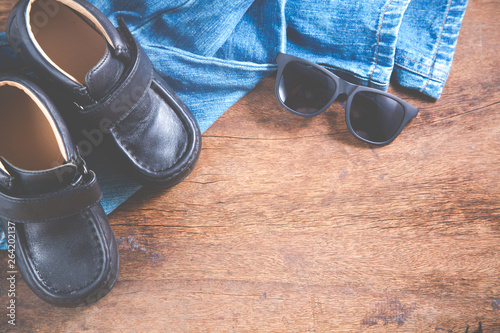 Accessories, Flat Lay of Baby clothes blue jeans, sneakers, sunglass on wooden background