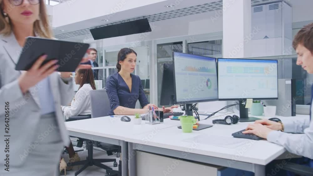 In the Big Busy Corporate Office Camera Zoom in On Female Manager Using Desktop Computer, Around Him Businesspeople and Experts Working with Clients, Having Discussions and Analysing Statistics
