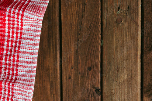 Red checkered picnic cloth on brown wooden table.