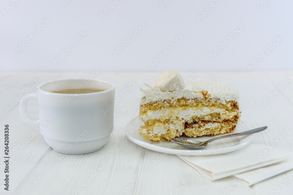 Cup of coffee and piece of cake on wooden table