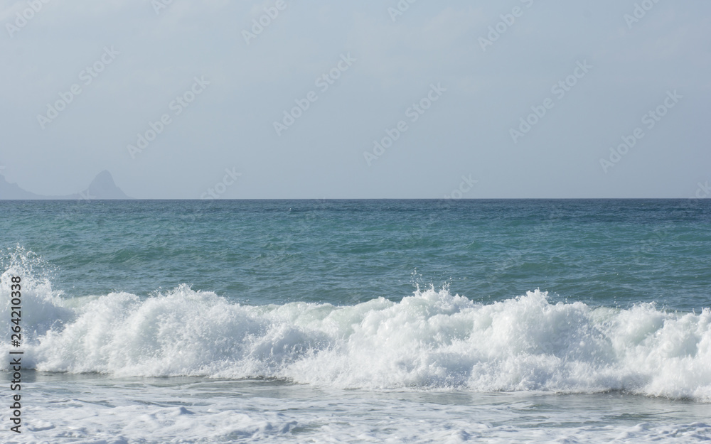 Scenic view of waves on sea beach and blue sky