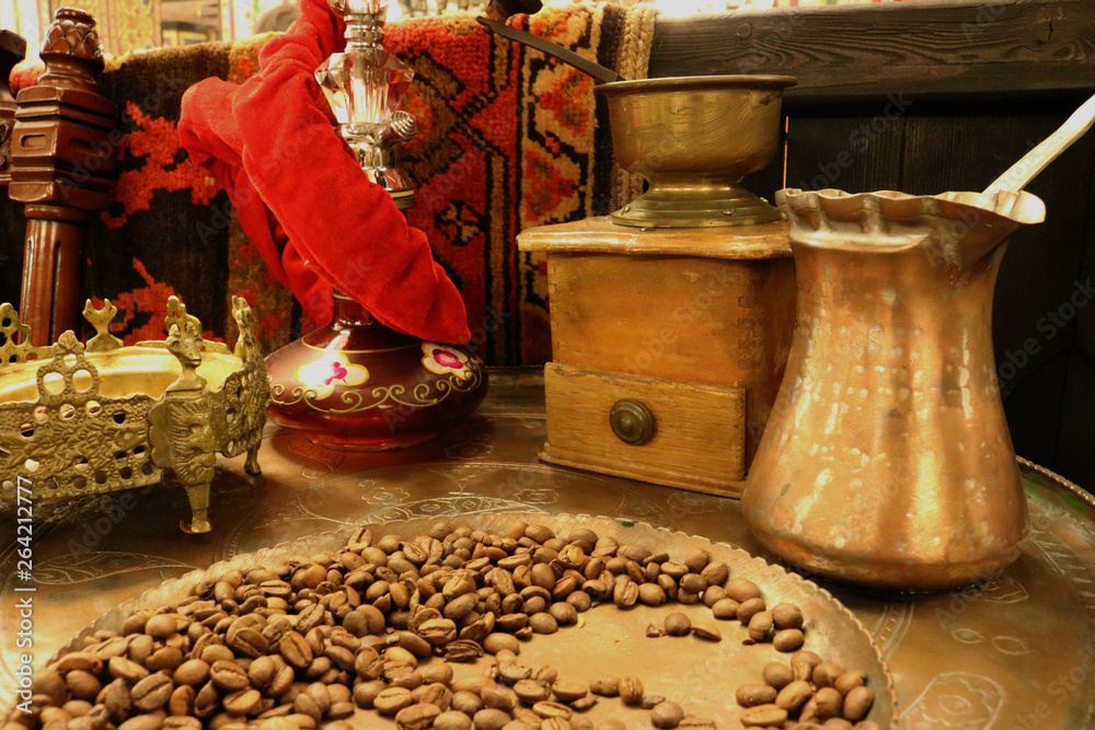 Copper coffee maker (turka), coffee grains and old coffee grinder on the table