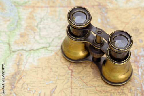 Vintage rustic binoculars standing on a map, background with copy space