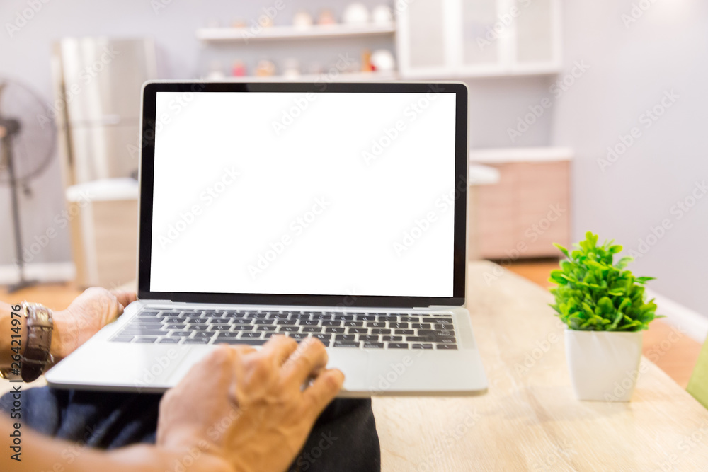 Mockup image of a businessman using laptop with blank white desktop screen working in home- Image Mockup image of a businessman using laptop with blank white desktop screen working in home- Image