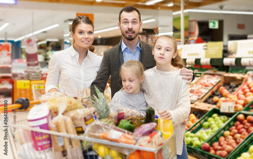 Family with  daughters choosing meal for home in supermarket