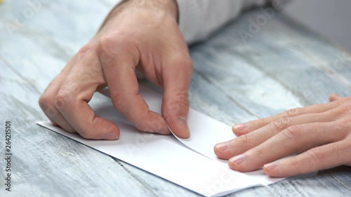 Fotografia Male hands folding white paper sheet
