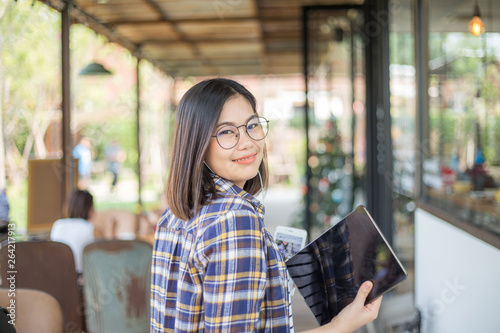 Attractive asian business casual women hold tablet computer in cafe