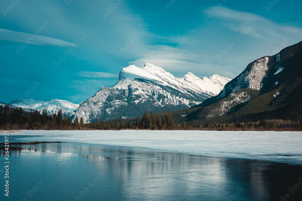 Panorama of Mount Rundle mountain peak with blue sky reflecting in Vermilion Lakes at Banff national park, Alberta Canada