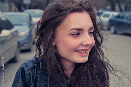 Cute long haired girl smiling in the street in windy day