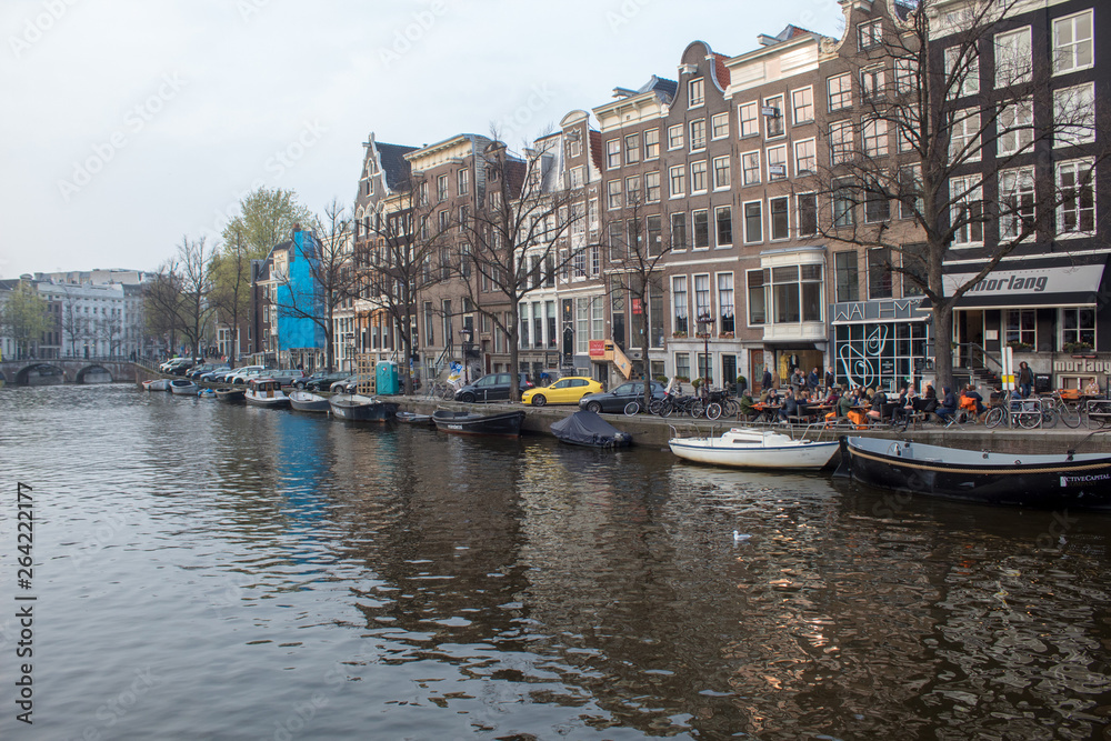 Walk the streets of Amsterdam. Canals, tulips, bicycles, boats.