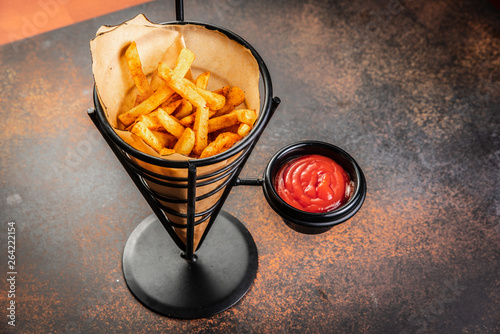 French fries in a paper bag with sauces. Top view.