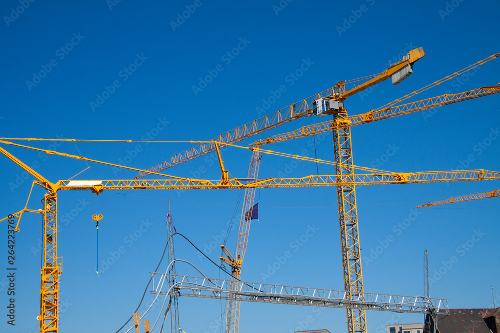 Lots of yellow cranes against a deep blue sky. Almost abstract composition with copy space Lots of yellow cranes against a deep blue sky. Almost abstract composition with copy space