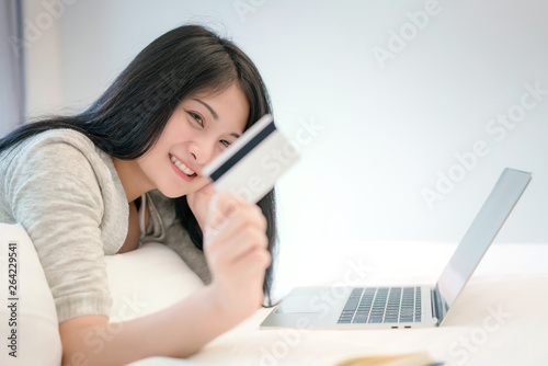 Young woman working on a laptop and uses credit card, bussiness and shopping concept