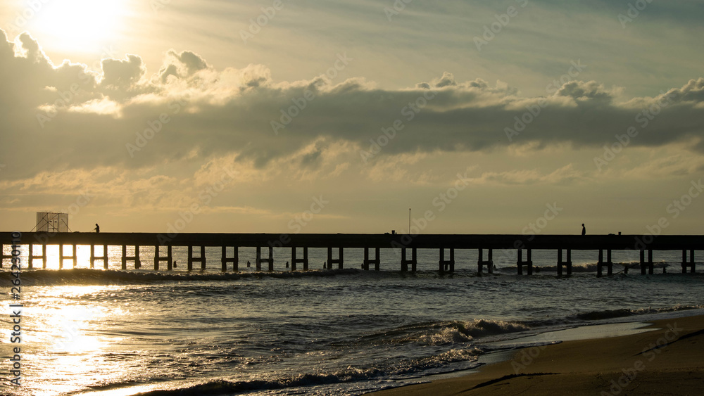 Silhouettes of fishermen fishing on  Bridge into the sea.