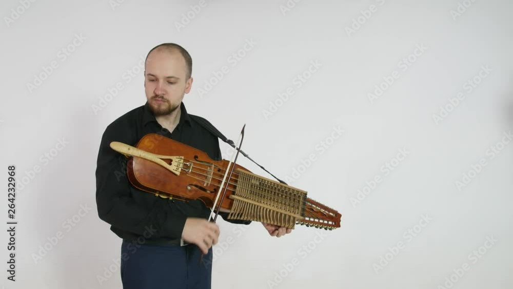 young musician demonstrates the technique of playing nickelharpa, a medieval authentic Swedish Scandinavian musical instrument