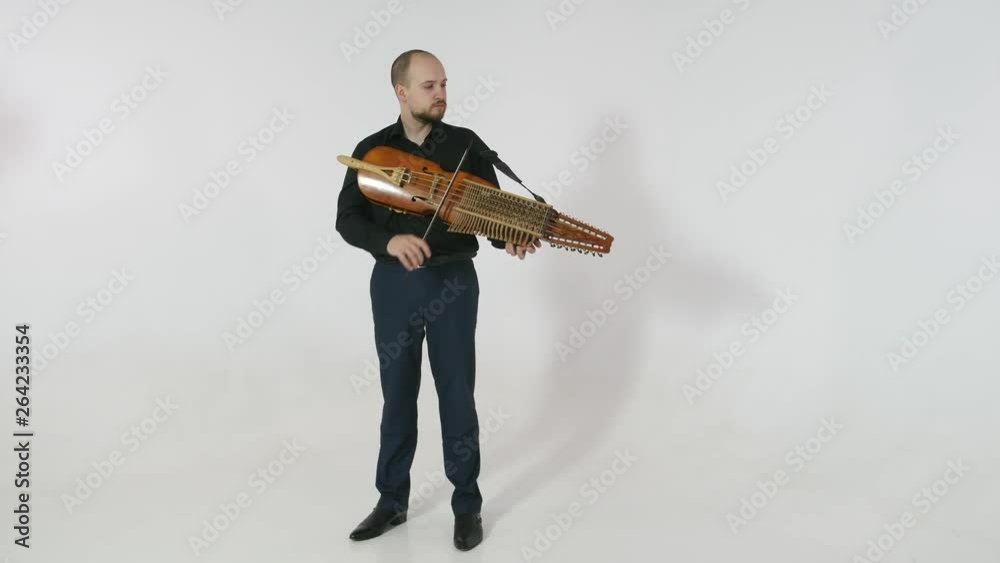 young musician demonstrates the technique of playing nickelharpa, a medieval authentic Swedish Scandinavian musical instrument