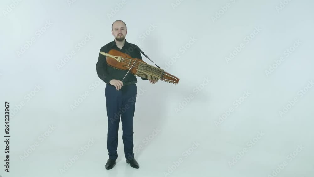 young musician demonstrates the technique of playing nickelharpa, a medieval authentic Swedish Scandinavian musical instrument
