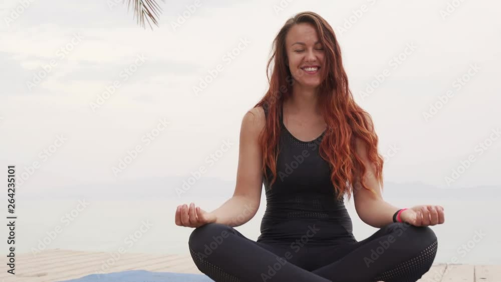 Close up portrait of smiling handsome female sitting in meditation pose on 4k Close up portrait of smiling handsome female sitting in meditation pose on 4k