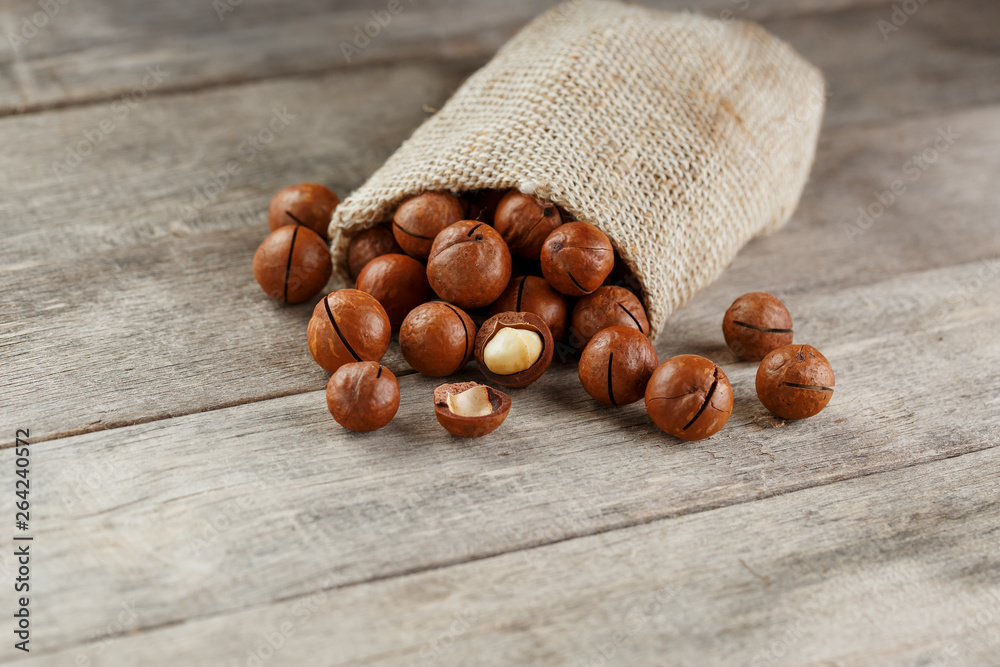 Macadamia nut on a wooden table in a bag, closeup, top view Macadamia nut on a wooden table in a bag, closeup, top view