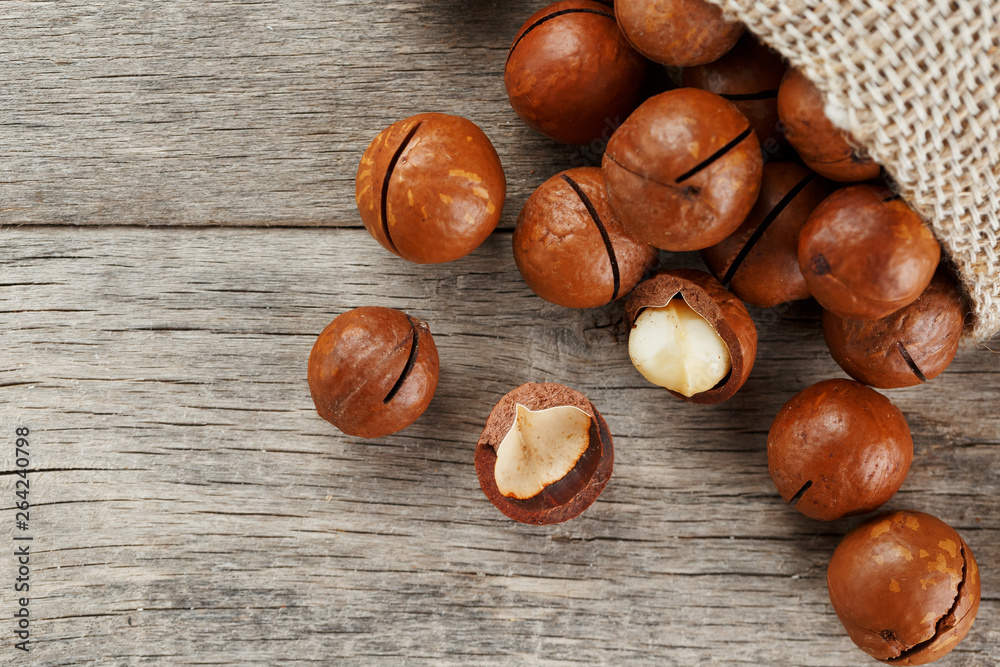 Macadamia nut on a wooden table in a bag, closeup, top view Macadamia nut on a wooden table in a bag, closeup, top view