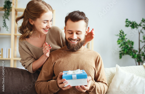 Happy married couple man and woman give a gift for holiday .