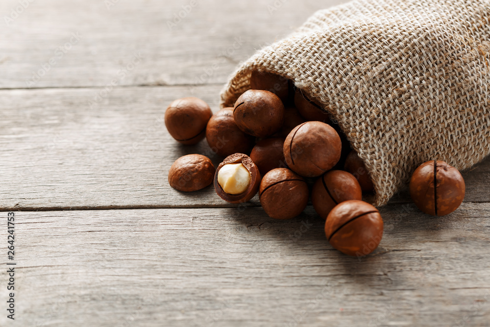 Macadamia nut on a wooden table in a bag, closeup, top view Macadamia nut on a wooden table in a bag, closeup, top view
