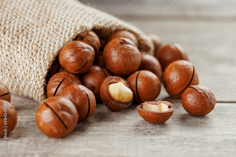 Macadamia nut on a wooden table in a bag, closeup, top view Macadamia nut on a wooden table in a bag, closeup, top view