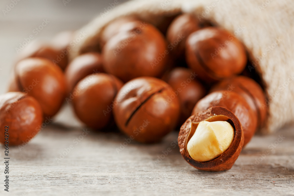 Macadamia nut on a wooden table in a bag, closeup, top view Macadamia nut on a wooden table in a bag, closeup, top view