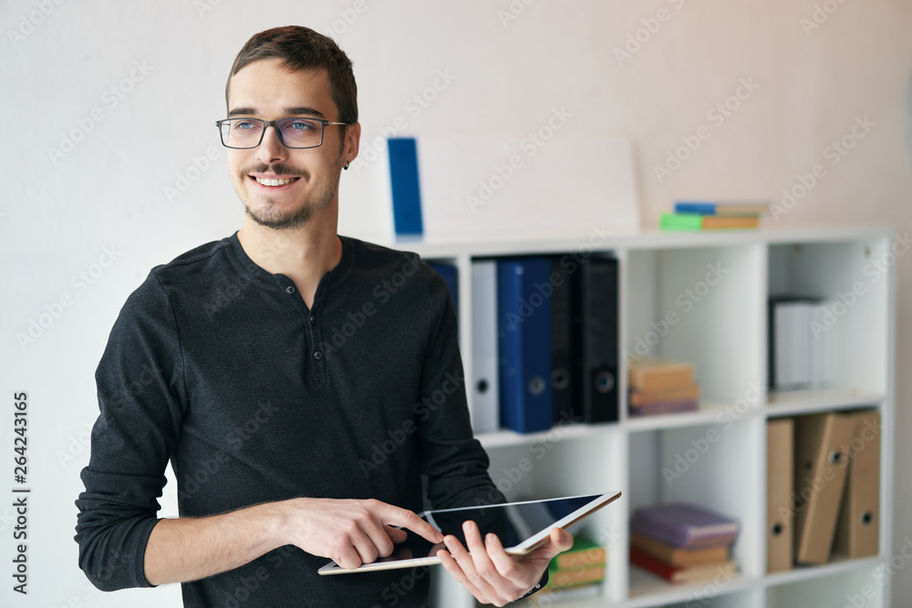 Young man working with tablet, receiving video call, talking with partners Young man working with tablet, receiving video call, talking with partners