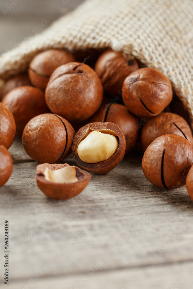 Macadamia nut on a wooden table in a bag, closeup, top view Macadamia nut on a wooden table in a bag, closeup, top view