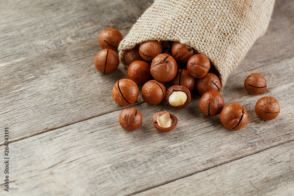 Macadamia nut on a wooden table in a bag, closeup, top view Macadamia nut on a wooden table in a bag, closeup, top view