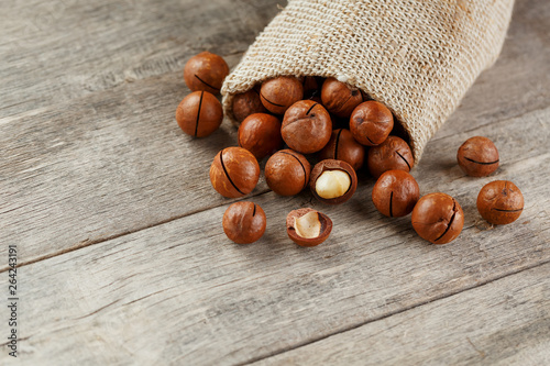 Macadamia nut on a wooden table in a bag, closeup, top view photo